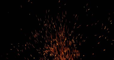 Gerçekçi ateş kıvılcımları havada uçuşuyor, siyah bir arka planda izole edilmiş. Sinematik VFX örtüsü, ateş parçacıkları etkisi ya da görsel element olarak mükemmel.