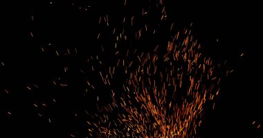 Gerçekçi ateş kıvılcımları havada uçuşuyor, siyah bir arka planda izole edilmiş. Sinematik VFX örtüsü, ateş parçacıkları etkisi ya da görsel element olarak mükemmel.