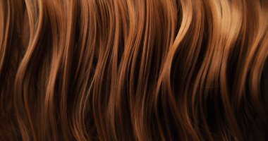 Dalgalı kahverengi saçların soyut dokusu zarif doğal dalgalar ve kıvrımlar oluşturuyor. Organik hareket, yumuşak ışık ve zengin tonlar sinematik güzellik arkaplanı ya da lüks görsel element oluşturur.