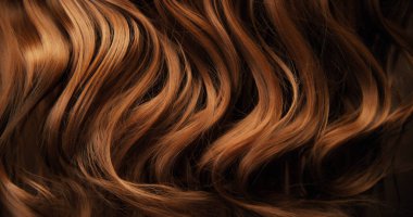 Dalgalı kahverengi saçların soyut dokusu zarif doğal dalgalar ve kıvrımlar oluşturuyor. Organik hareket, yumuşak ışık ve zengin tonlar sinematik güzellik arkaplanı ya da lüks görsel element oluşturur.