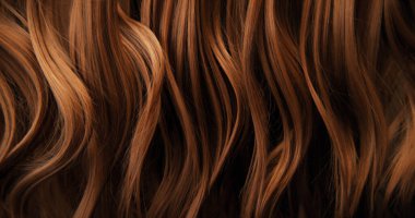 Dalgalı kahverengi saçların soyut dokusu zarif doğal dalgalar ve kıvrımlar oluşturuyor. Organik hareket, yumuşak ışık ve zengin tonlar sinematik güzellik arkaplanı ya da lüks görsel element oluşturur.