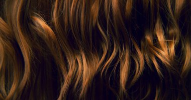 Dalgalı kahverengi saçların soyut dokusu zarif doğal dalgalar ve kıvrımlar oluşturuyor. Organik hareket, yumuşak ışık ve zengin tonlar sinematik güzellik arkaplanı ya da lüks görsel element oluşturur.