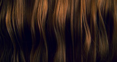 Dalgalı kahverengi saçların soyut dokusu zarif doğal dalgalar ve kıvrımlar oluşturuyor. Organik hareket, yumuşak ışık ve zengin tonlar sinematik güzellik arkaplanı ya da lüks görsel element oluşturur.
