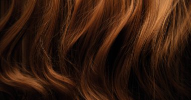 Dalgalı kahverengi saçların soyut dokusu zarif doğal dalgalar ve kıvrımlar oluşturuyor. Organik hareket, yumuşak ışık ve zengin tonlar sinematik güzellik arkaplanı ya da lüks görsel element oluşturur.