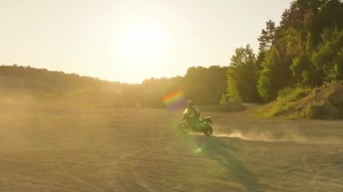 Bir Yalnız Motosikletçi Gün Doğumu sırasında Açık Arazide Geziniyor, Sinema Yavaş Filminde Yakalandı. Kamera Sürücüyü İzliyor, Altın Saatte Hareket, Işık ve Özgürlüğü Vurguluyor.