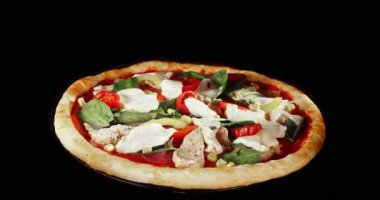 Pişirme işlemi sırasında pizza dönüşümlü, siyah arka planda izole edilmiş. Sinema stüdyosunun çekimleri yemek pişirme süresinin ilerlemesini, erimiş peyniri ve taze malzemeleri gösteriyor. Yemek, yemek ve restoran kavramları için mükemmel..