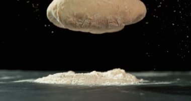 Hamur Topu 'nun un içine düşmesi Süper Yavaş Hareket' te 1000 fp hızında. Ahşap Masa 'da Un Patlaması Hazırlama Etkisi. Kara Arkaplanda İzole Edilmiş.