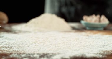 Hamur Topu 'nun un içine düşmesi Süper Yavaş Hareket' te 1000 fp hızında. Ahşap Masa 'da Un Patlaması Hazırlama Etkisi. Kara Arkaplanda İzole Edilmiş.