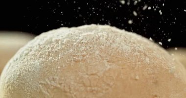 Siyah zemin üzerinde izole edilmiş mayalanmış hamur somununun statik görüntüsü. Süper yavaş çekimde un düşüyor. 1000 fps. Pişirme, zanaatkar ekmek yapma ve hamur hazırlama kavramı.