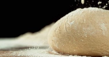 Siyah zemin üzerinde izole edilmiş mayalanmış hamur somununun statik görüntüsü. Süper yavaş çekimde un düşüyor. 1000 fps. Pişirme, zanaatkar ekmek yapma ve hamur hazırlama kavramı.