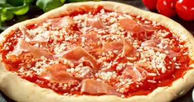 Kurutulmuş kekikotunun süper yavaş çekimde domates sosu ve mozzarella ile hazırlanmış pizzanın üzerine düşmesi. Çiğ hamur taze malzemelerle çevrili. Pizza çeşnisi ve pişirme hazırlığı kavramı.