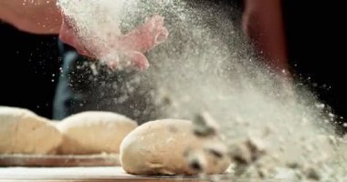 Süper yavaş çekim, fırıncıların el attığı 1000 fp yakın çekim ahşap masaya yükselmiş hamur. Sinematik pişirme konsepti, zanaatkar ekmek hazırlama ve doku detayı. Hız rampası etkisi.