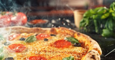 Erimiş peynirli, sıcak ve iştah açıcı ışıkta altın hamurlu yeni pişmiş bir pizzanın yakın çekimi. Zengin dokusu ve davetkar sunumu olan klasik konforlu yiyecek konsepti.