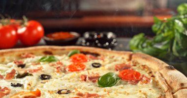 Erimiş peynirli, sıcak ve iştah açıcı ışıkta altın hamurlu yeni pişmiş bir pizzanın yakın çekimi. Zengin dokusu ve davetkar sunumu olan klasik konforlu yiyecek konsepti.