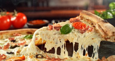 Yeni pişmiş bir pizza diliminin sıcak ve iştah açıcı bir ışıkta erimiş peynir ve altın kabukla yakın çekimi. Lezzetli ve aromalı klasik konforlu yemek konsepti..