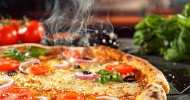 Erimiş peynirli, sıcak ve iştah açıcı ışıkta altın hamurlu yeni pişmiş bir pizzanın yakın çekimi. Zengin dokusu ve davetkar sunumu olan klasik konforlu yiyecek konsepti.