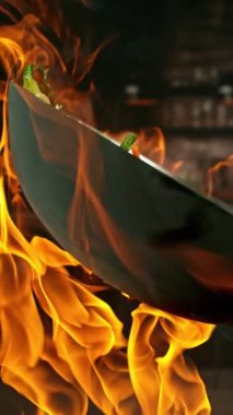 Sebze ve Etli Uçan Asya Yemeklerinin Süper Yavaş Hareketi. Yüksek Hız Sinema Kamerası 'nda çekildi, 600 fps. Kara Arkaplan 'da izole edilmiş, Alevler Yanıp sönüyor. Dikey Görünüm Oranı.