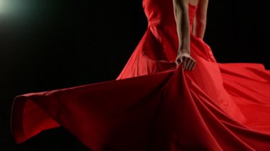 Yakut kırmızısı elbiseli çarpıcı siyah saçlı kadın ve yüksek topuklu zarif siyah arka plan pozu, Süper Yavaş Çekimde Yakalandı. Hız Rampası Efekti.