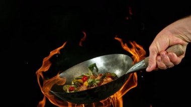 Et ve sebzeli Uçan Asya Yemeklerinin Süper Yavaş Hareketi. High Speed Cinema Camera 'da çekildi, 1000 fps. Arka planda Görüntü Mutfağı İçi.