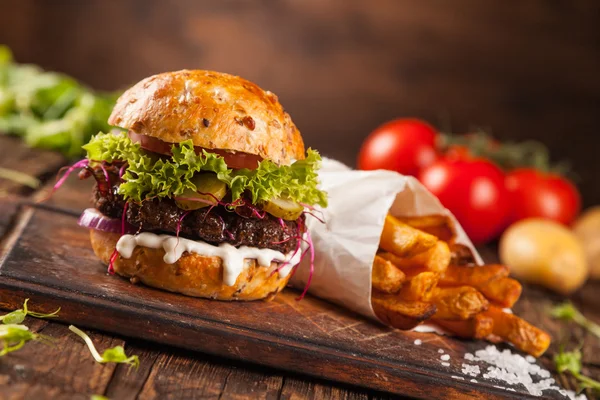 Hambúrguer delicioso em madeira — Fotografia de Stock