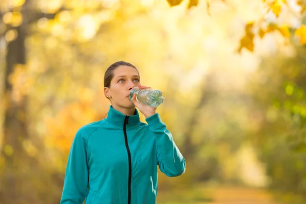 Portrait of young brunette woman drinking water — Stock Photo, Image
