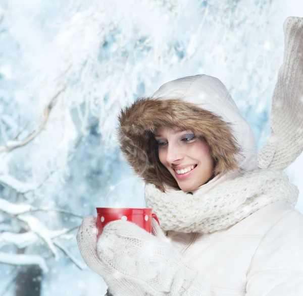 Hermosa mujer morena con taza en el paisaje de invierno — Foto de Stock