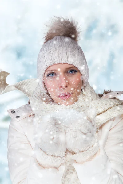 Brünettes Mädchen bläst Schnee aus den Händen — Stockfoto