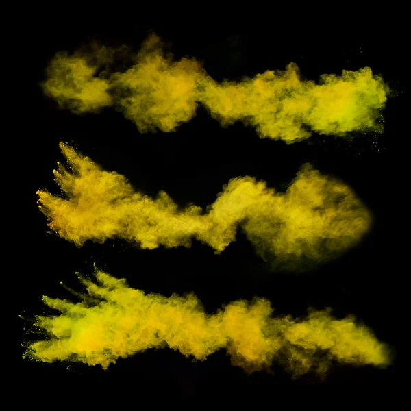 Freeze motion of yellow dust explosions on black background — Stok fotoğraf