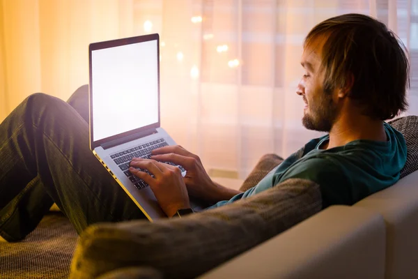 Homem trabalhando no laptop no interior acolhedor casa — Fotografia de Stock