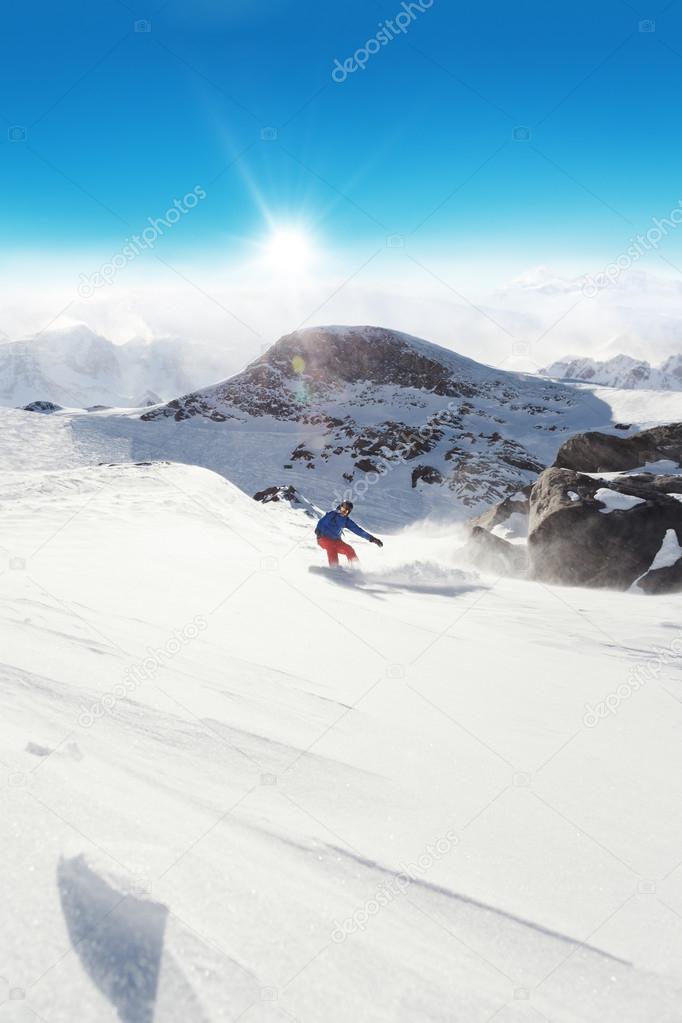 Snowboarder running down on piste