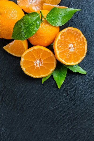 Mandarina fresca sobre piedra negra — Foto de Stock