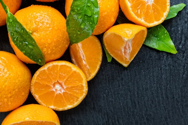 Mandarina fresca sobre piedra negra — Foto de Stock