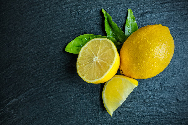 Свежий лимон на черном камне
