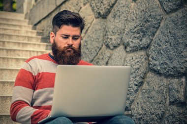 Oturma ve dizüstü bilgisayar kullanarak genç yenilikçi