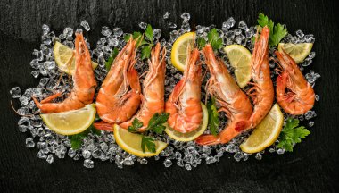 Cooked prawns served on black stone clipart