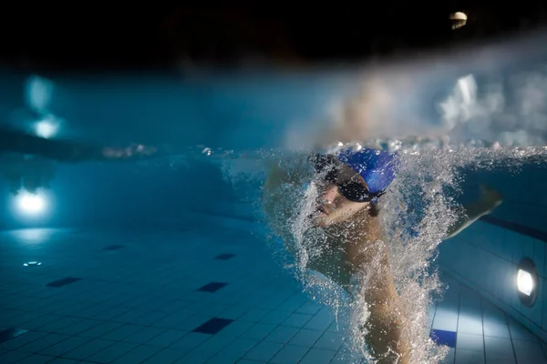 Mladý muž plavání v bazénu — Stock fotografie