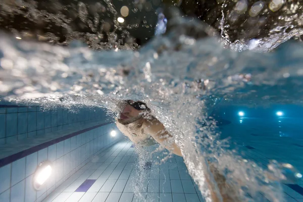 Ung man simmar i poolen — Stockfoto