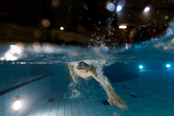 Mladý muž plavání v bazénu — Stock fotografie