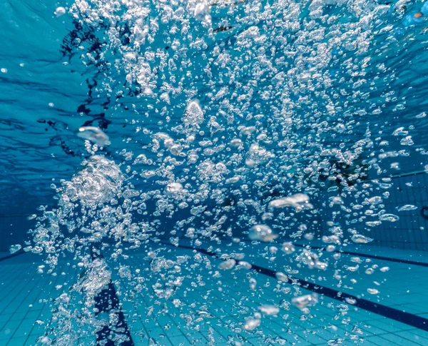 Air bubbles in clear blue water in pool — Stock Photo, Image