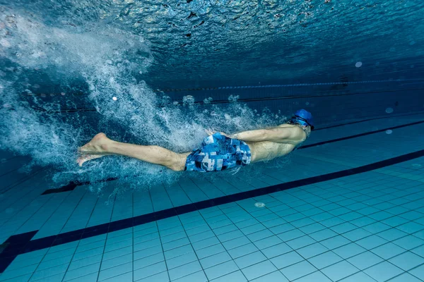 Ung man simmar i poolen — Stockfoto
