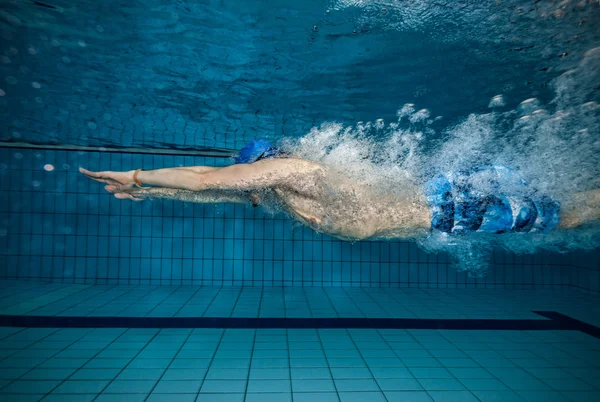 Giovane uomo nuoto in piscina — Foto Stock