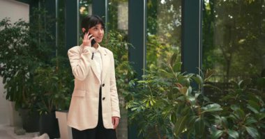 Smartphone kullanan mutlu, İspanyol iş kadını. Motivasyon, Ofiste Başarı. Heyecanlı, Çalışan, Avukat, Kadın İş Kadını Şirket İşi. Sera arka planı.