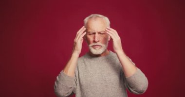 Üzücü, stresli, baş ağrısı çeken, hastalıklı emekli erkek, kırmızı arka planda artan kafa içi basıncı var. Tedavi kavramı