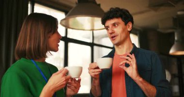 Gülümseyen başarılı meslektaşlar keyifli bir mola sırasında kahve içiyorlar. Kahve molası