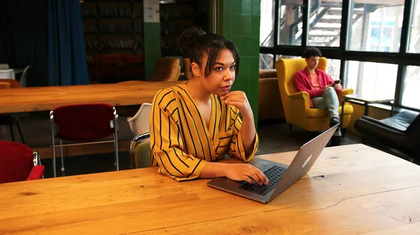 Kendine güvenen başarılı bir kadın, dizüstü bilgisayar kullanan, postaları kontrol eden, masada oturan, birlikte çalışan bir işçi. Kopya yazarı klavyeye yazı yazıyor. Çevrimiçi teknoloji kavramı