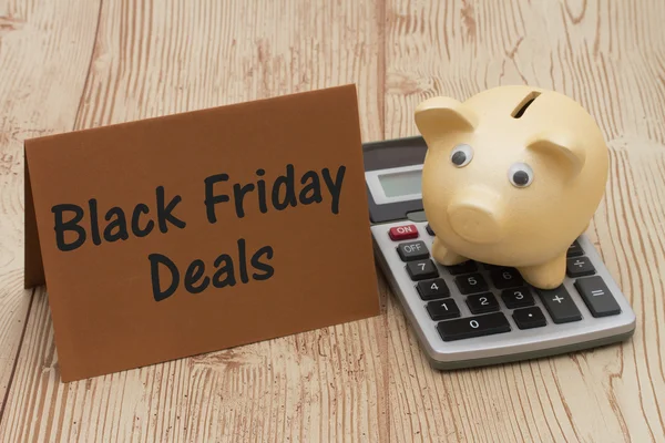Black Friday Deal, A golden piggy bank, card and calculator on w — Stock Photo, Image