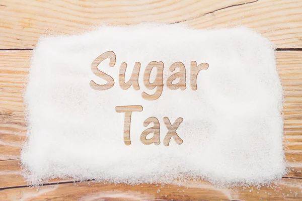Gros plan sur le sucre avec texte Taxe de vente sur le bois altéré backgrou — Photo