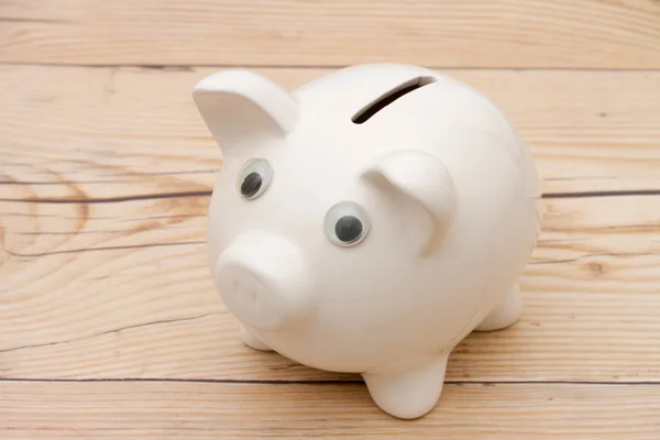 Een witte piggy bank op verweerd hout — Stockfoto