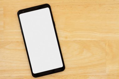 Ahşap masadaki boş ekran cep telefonu ve ofisiniz veya teknik mesajınız için alanı kopyalayın