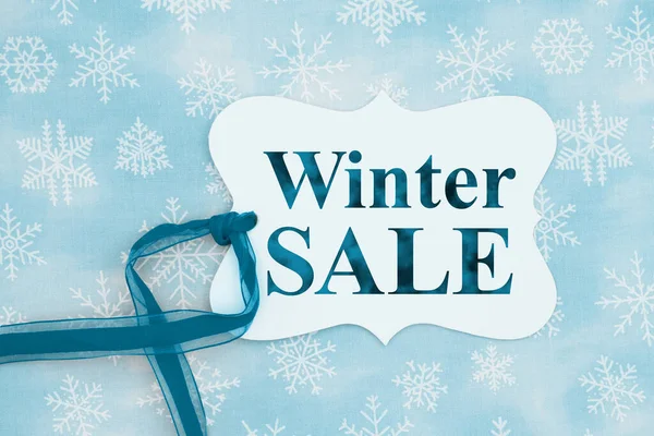 Winter Sale Üzenet Egy Ajándék Címke Egy Kék Szalag Hópelyhek — Stock Fotó